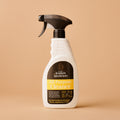 White spray bottle with black nozzle on a beige background