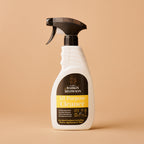 White spray bottle with black nozzle on a beige background