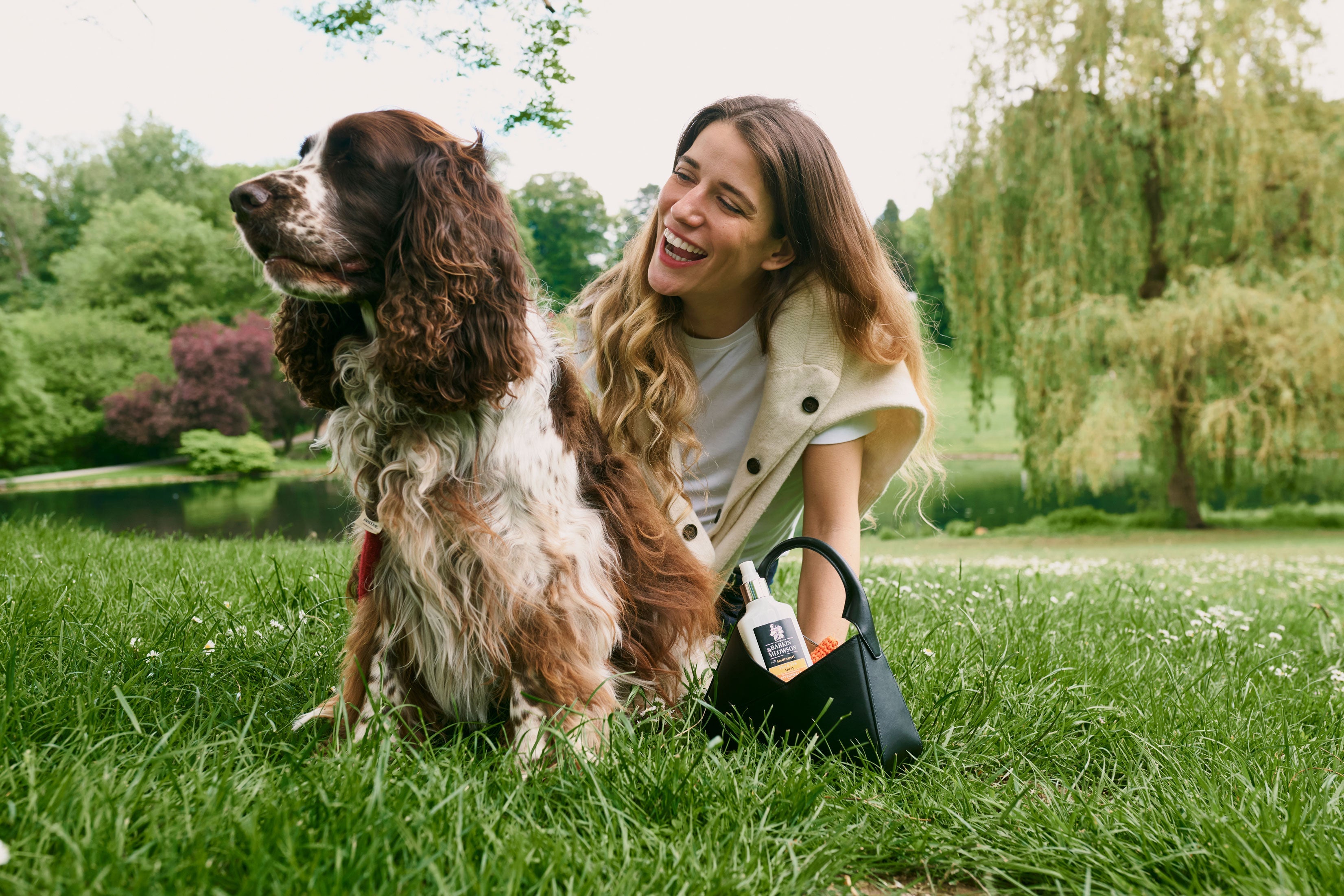 Woman and dog sitting on grass in a park