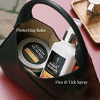 Barking Meowson pet care products including a jar and bottle in a black bag on a pink surface.
